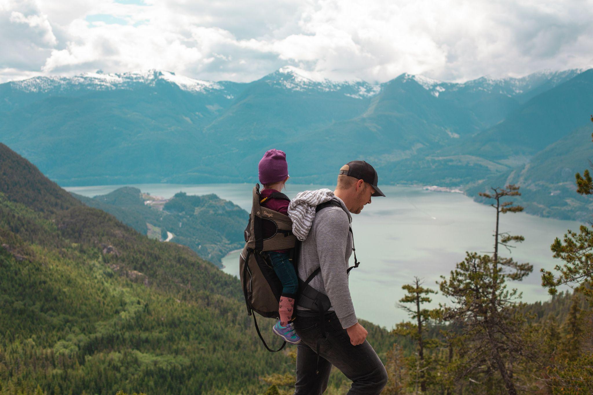 Man carrying baby near lake